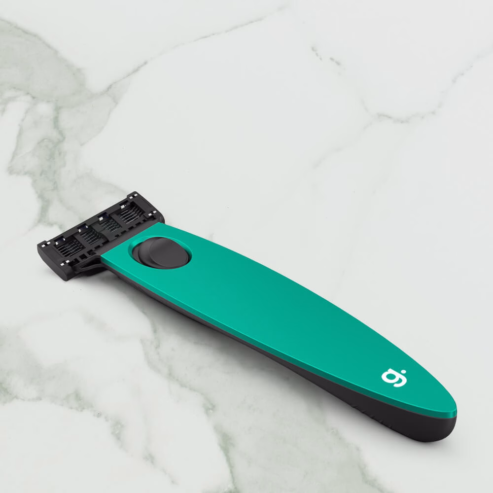 Green razor on marble surface.
