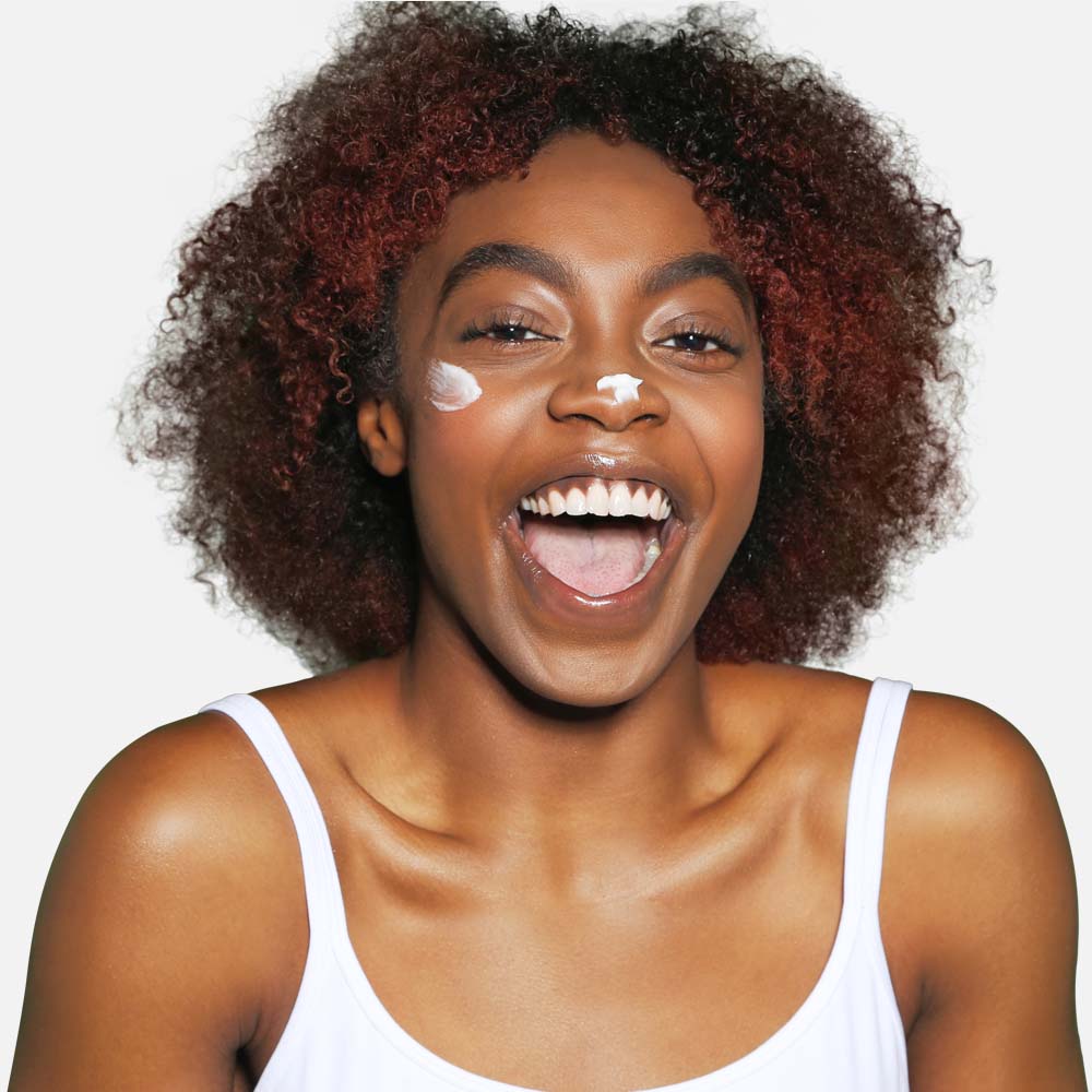 Woman applying face SPF50 sunscreen