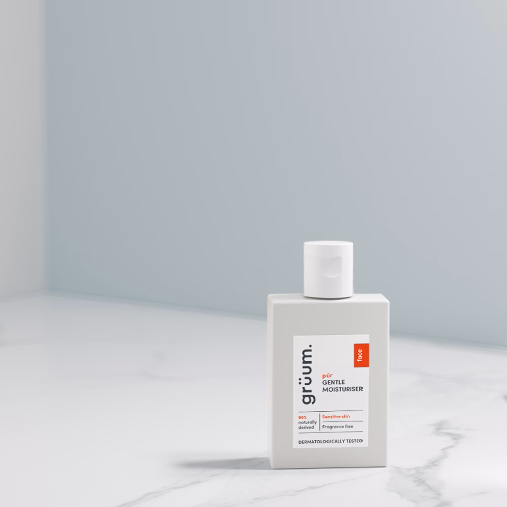 White bottle of moisturizer on marble surface.