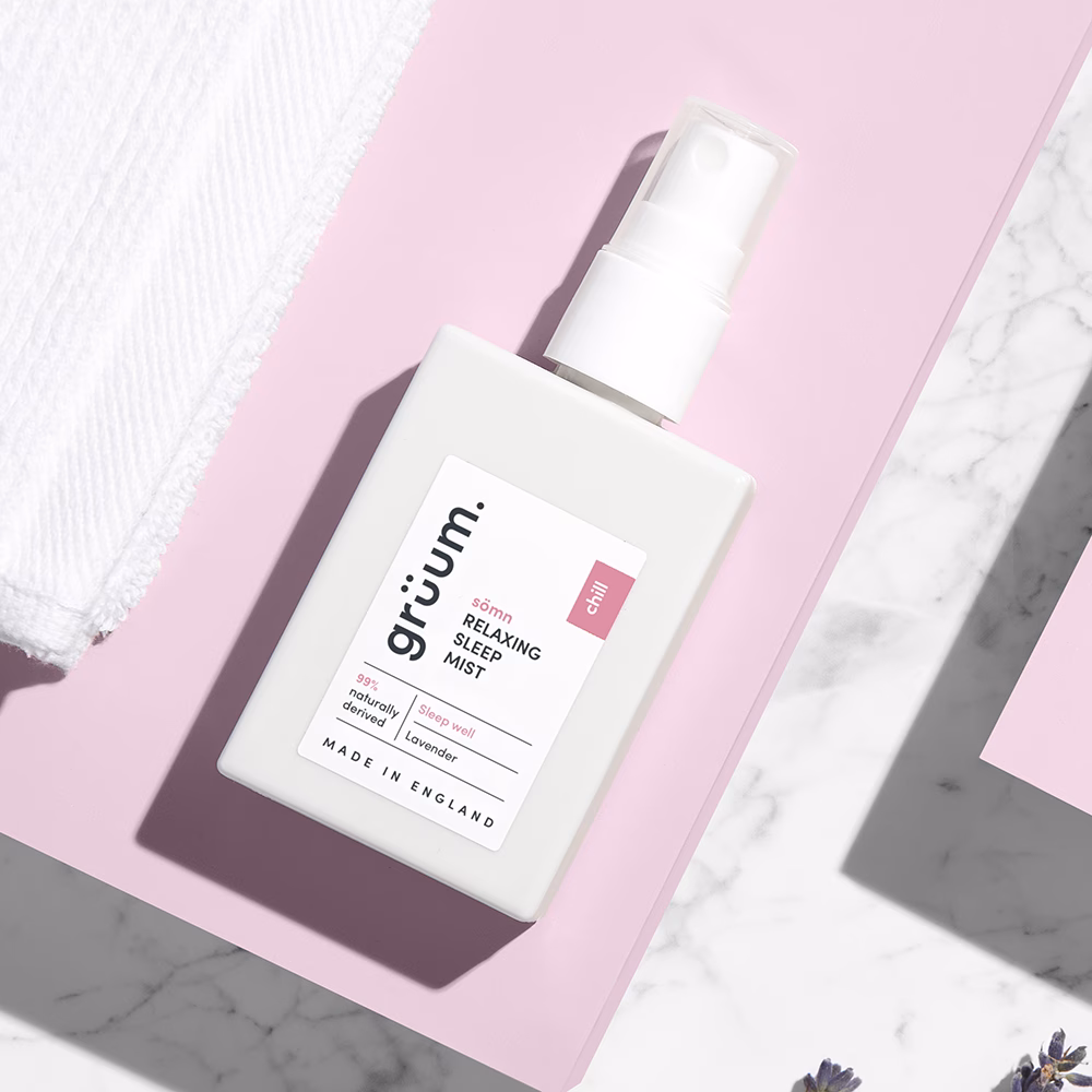 Sleep mist bottle on pink surface.