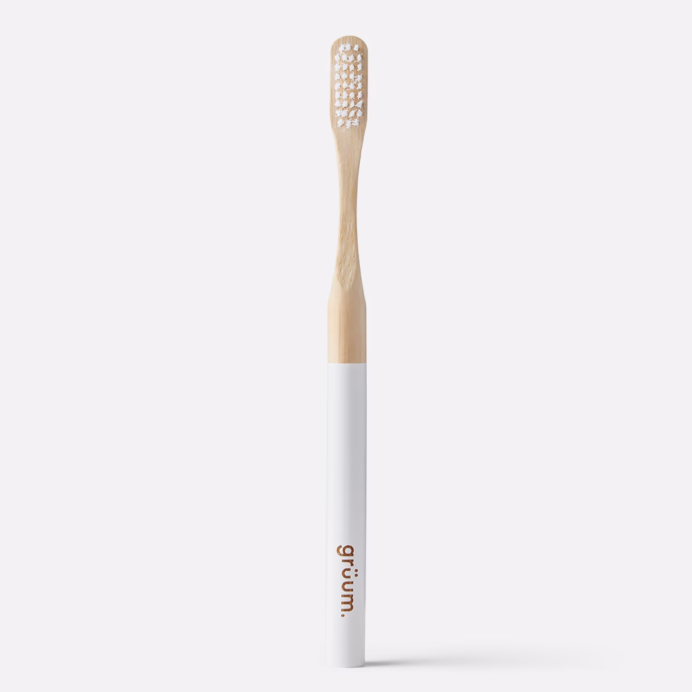 Bamboo toothbrush with white handle.
