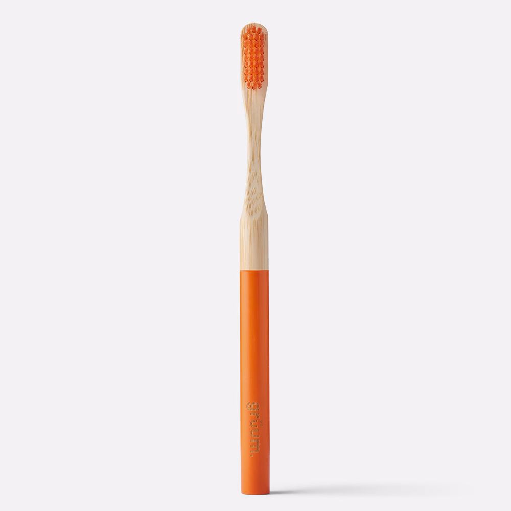 Orange toothbrush with bamboo handle.