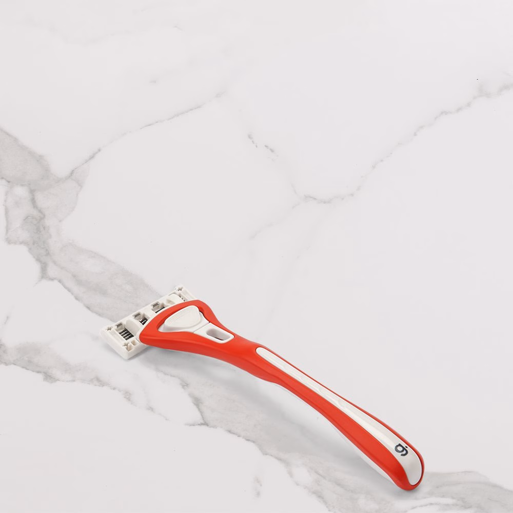 Red and white razor on marble
