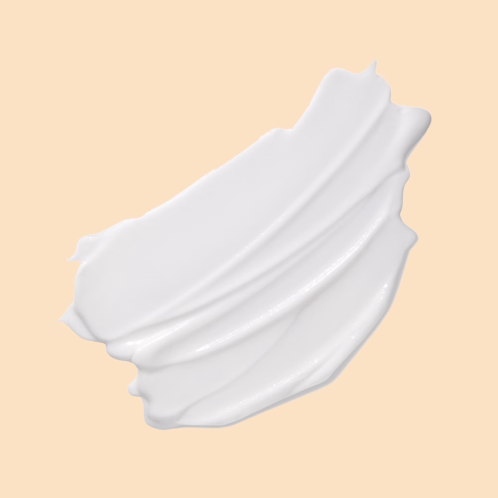 White cream smear on beige background.