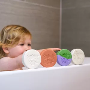 Child in bath with colorful soaps