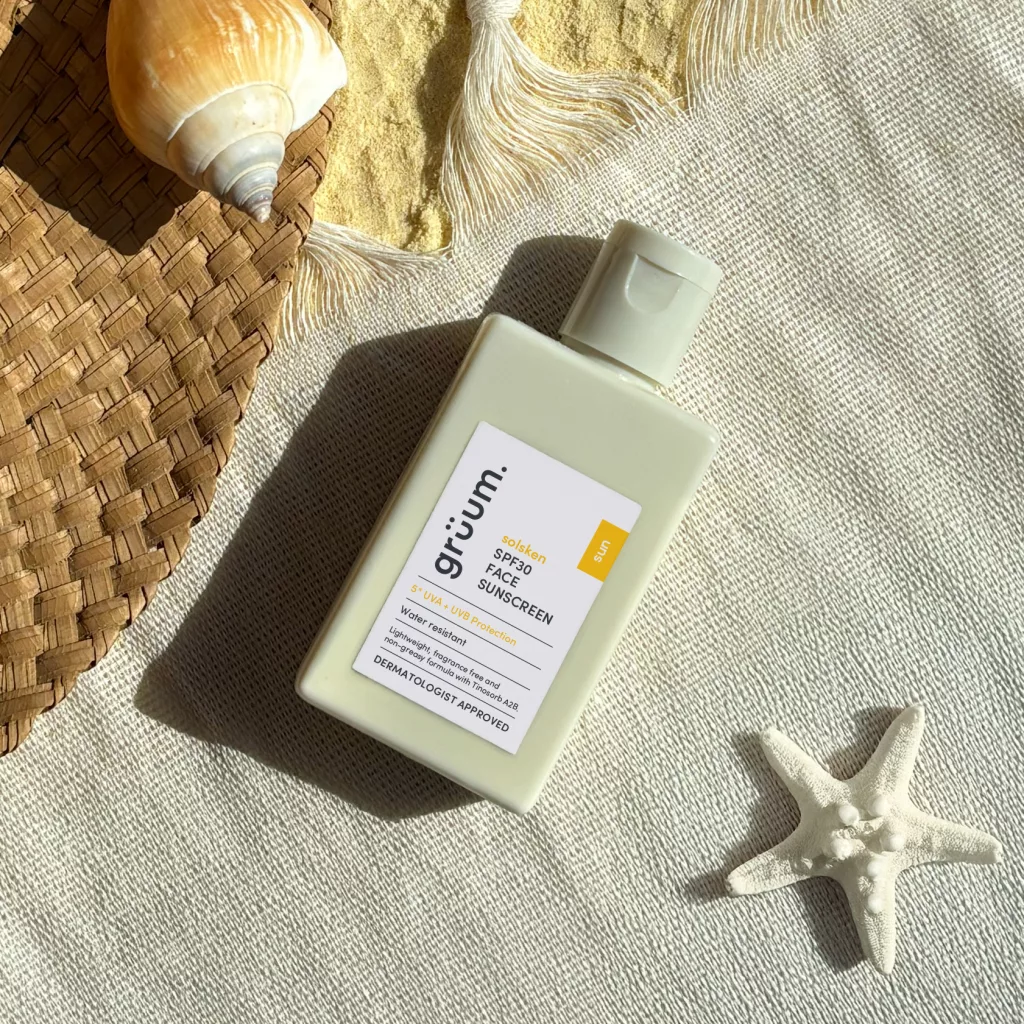 Sunscreen bottle on fabric with shells