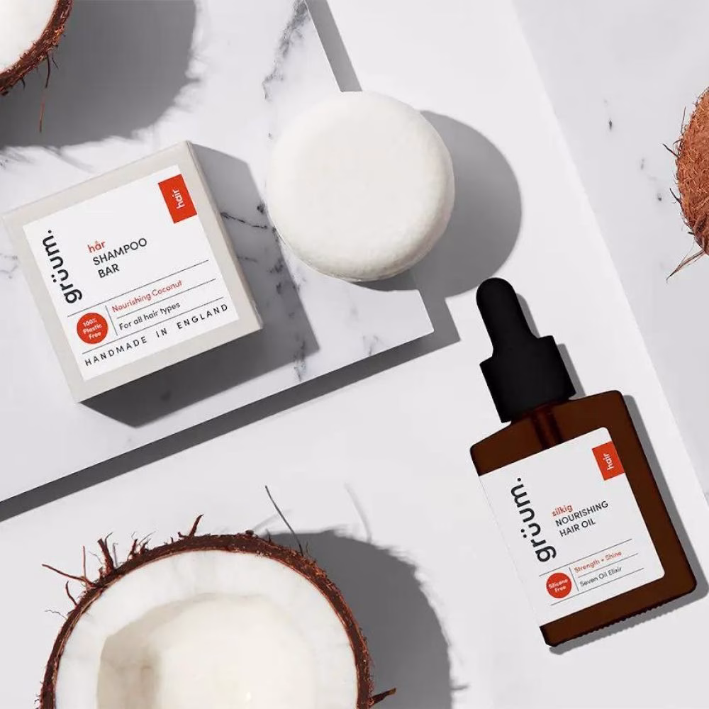 Shampoo bar, oil, and coconuts on marble