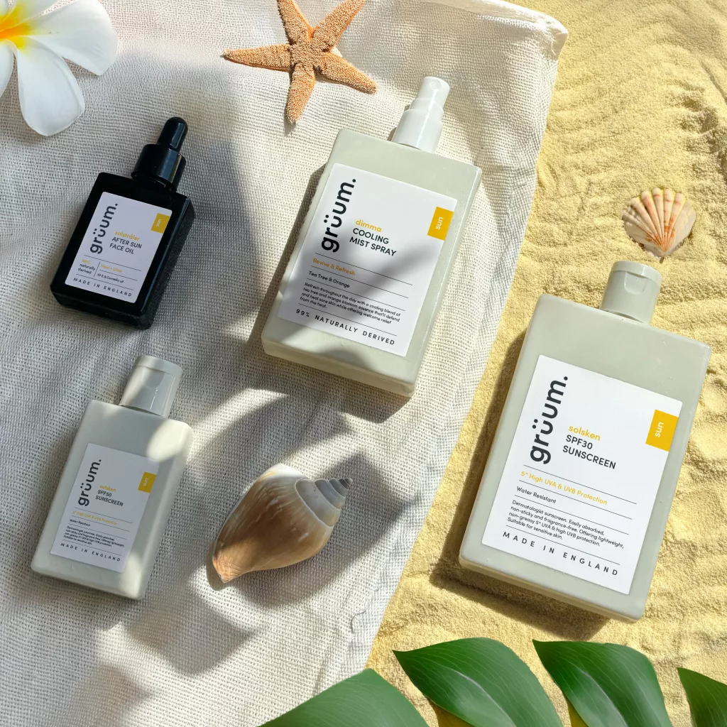 Beach-themed skincare products on sand and cloth.