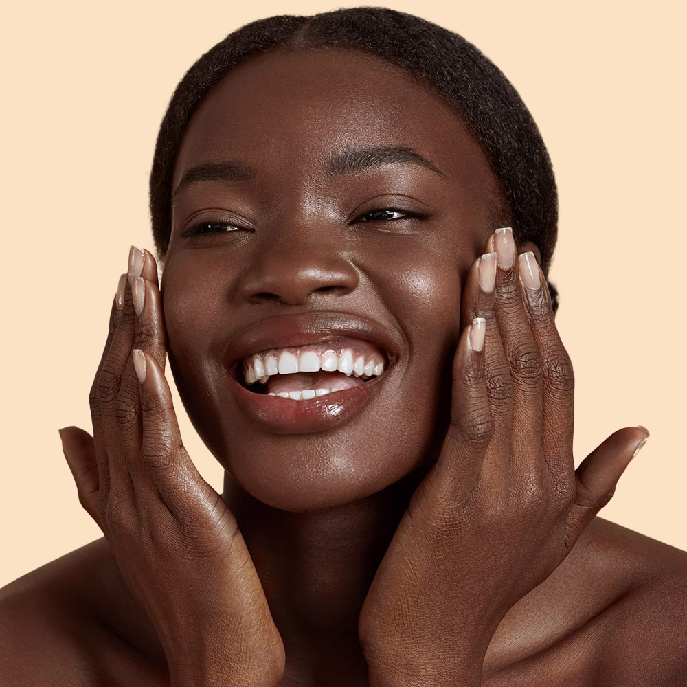 Smiling person touching face with joy.
