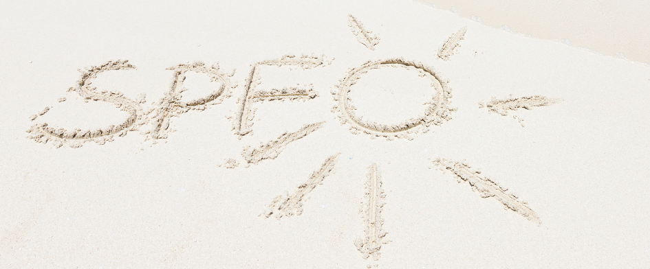 Sand writing spelling SPF with sun design.