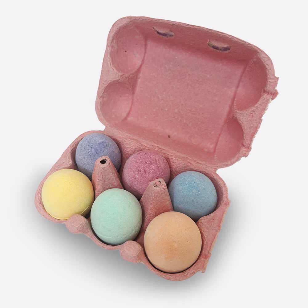Colorful chalk eggs in pink carton