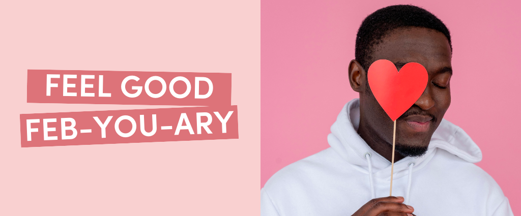 Man holding heart cutout near eye