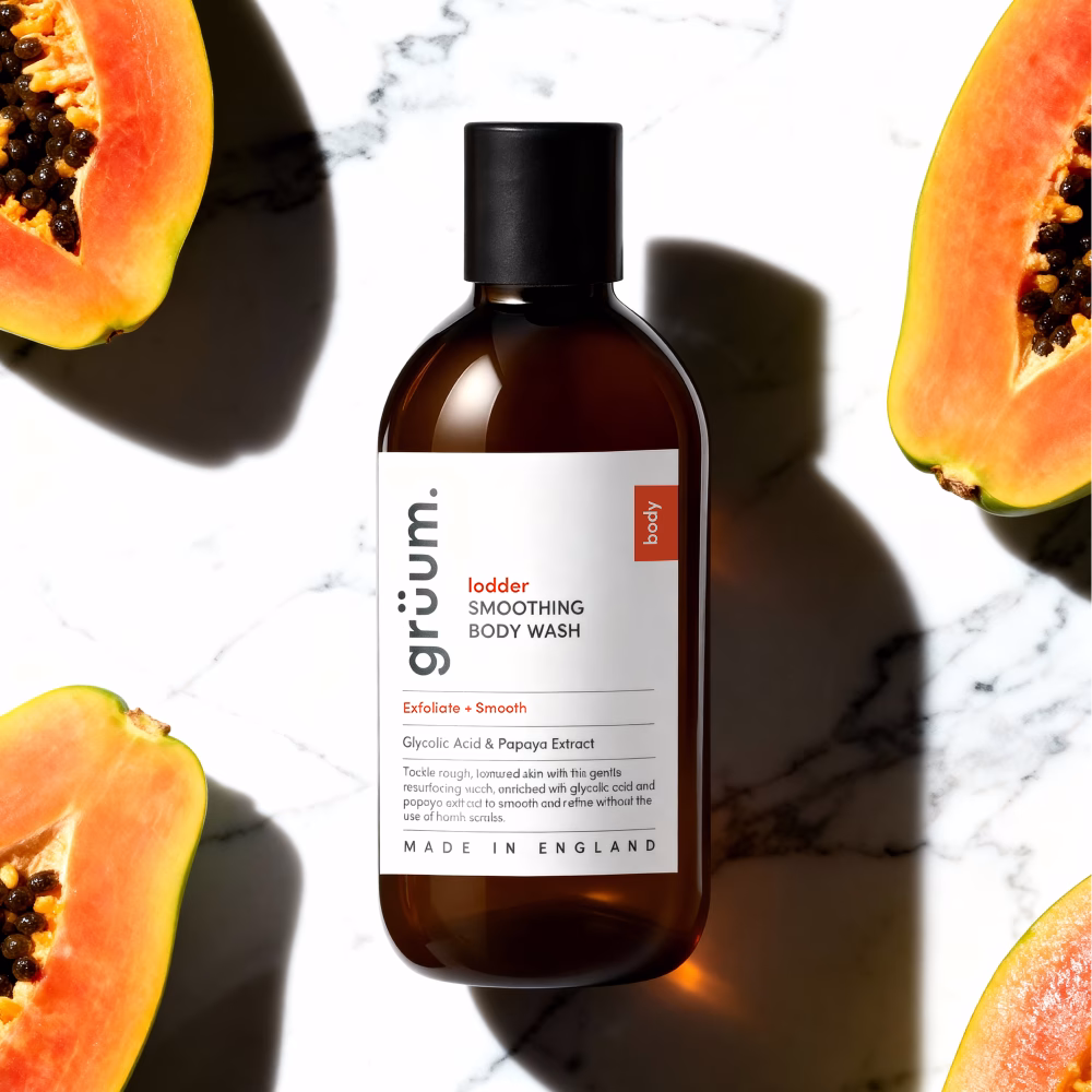 Body wash with papayas on marble surface.