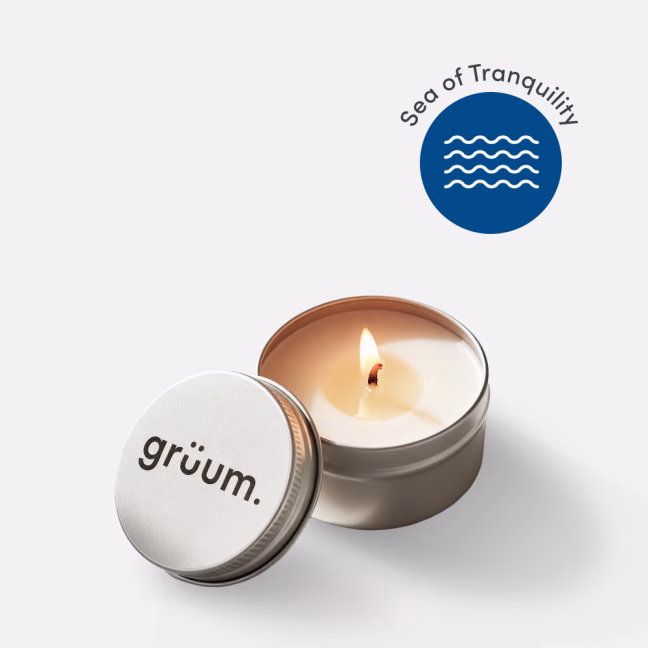 Small candle with branding and logo.