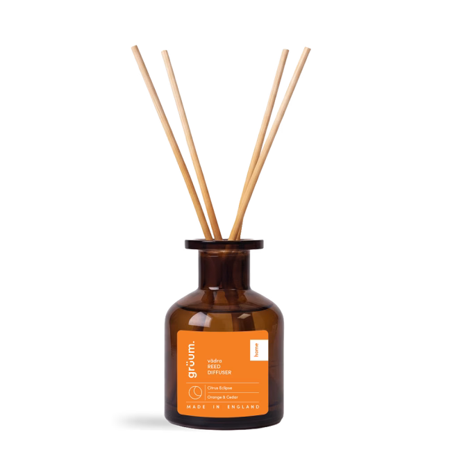 Brown reed diffuser bottle on black background.