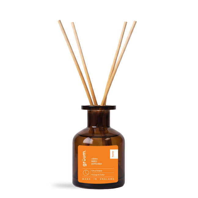 Brown reed diffuser bottle on black background.
