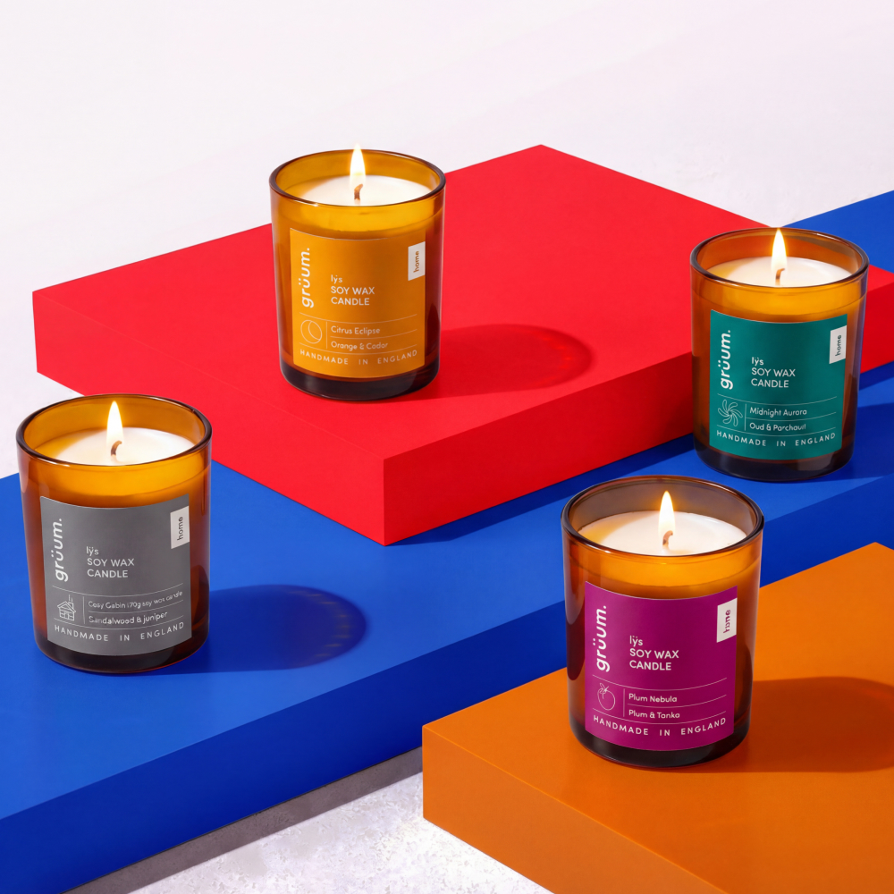 Four scented candles on colored blocks.